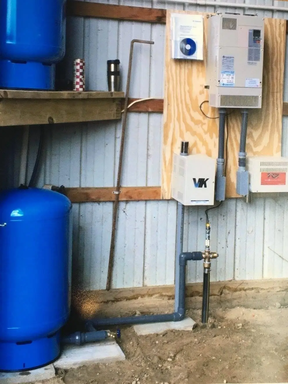 A pressure tank and controls installed in a basement.