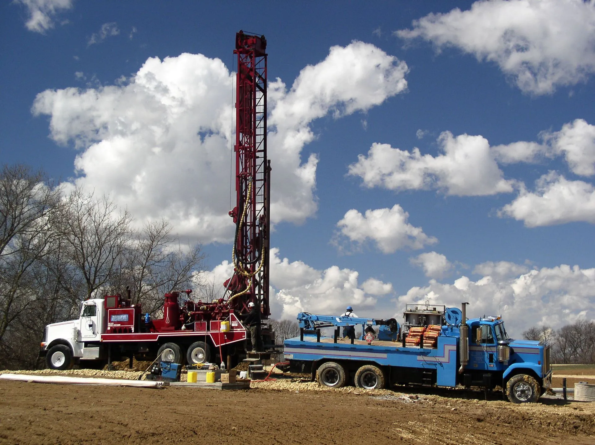 Well drilling rig casing a new borehole to protect the aquifer