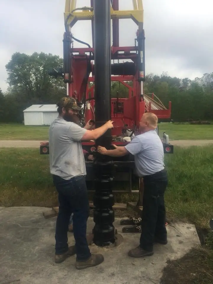 Crew working at the controls of the drill rig.