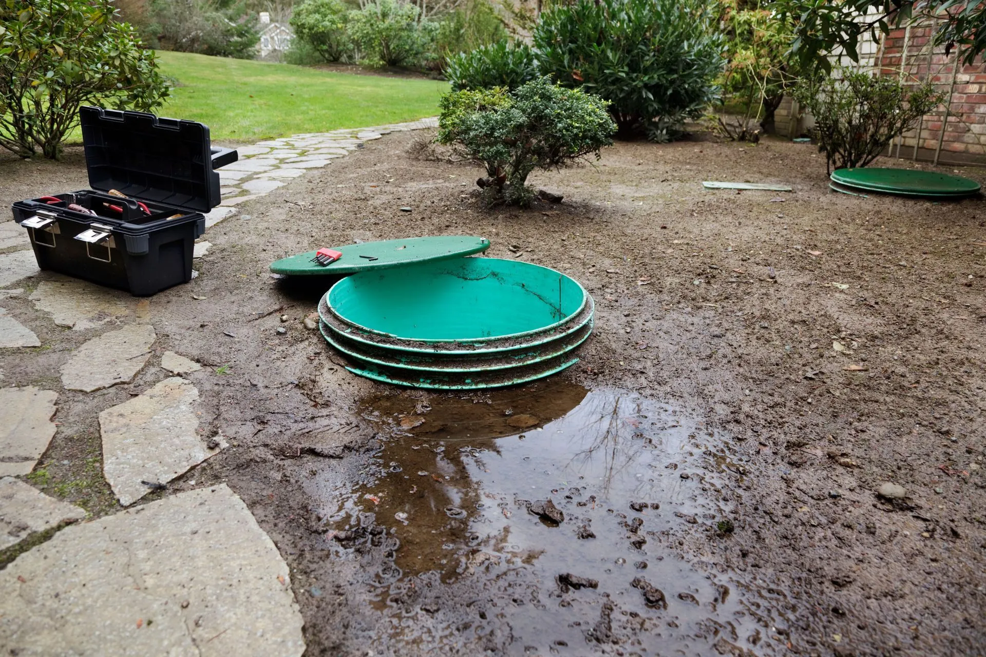 Serviced well caps set into a landscaped yard after a maintenance visit