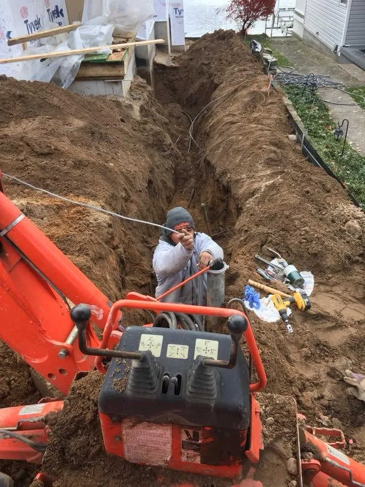 Trenching in the water line between the wellhead and the building.