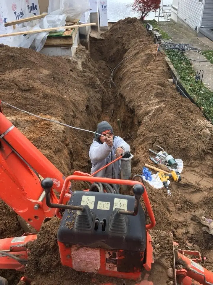 Trenching in the water line between the wellhead and the building.